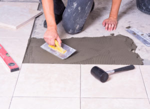 Tiler installing ceramic tiles on a floor