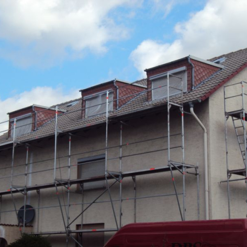 Sanierung eines Mehrfamilienhaus-Daches mit Beschichtung in Klassischrot