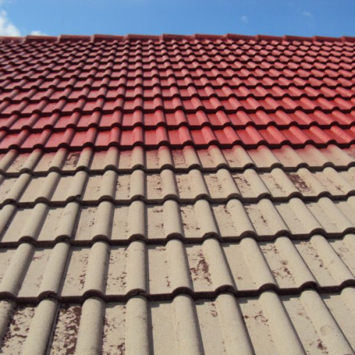 Sanierung eines Mehrfamilienhaus-Daches mit Beschichtung in Klassischrot