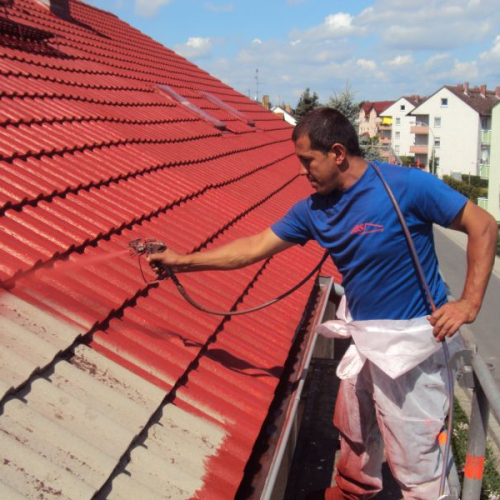 Sanierung eines Mehrfamilienhaus-Daches mit Beschichtung in Klassischrot