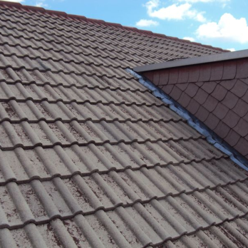 Sanierung eines Mehrfamilienhaus-Daches mit Beschichtung in Klassischrot