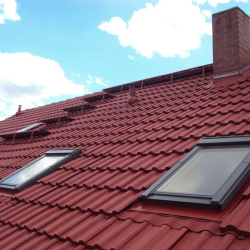 Sanierung eines Mehrfamilienhaus-Daches mit Beschichtung in Klassischrot