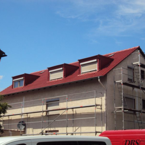 Sanierung eines Mehrfamilienhaus-Daches mit Beschichtung in Klassischrot