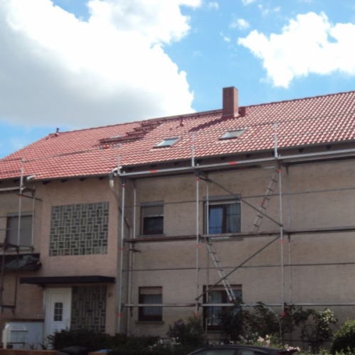 Sanierung eines Mehrfamilienhaus-Daches mit Beschichtung in Klassischrot