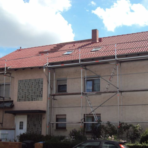 Sanierung eines Mehrfamilienhaus-Daches mit Beschichtung in Klassischrot