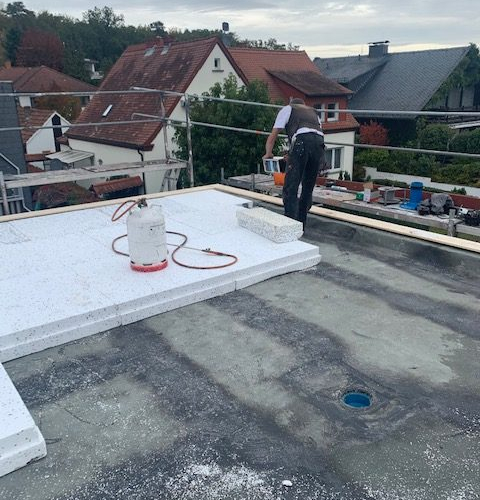 Flachdachaufbau mit Dämmung und Fassadensanierung